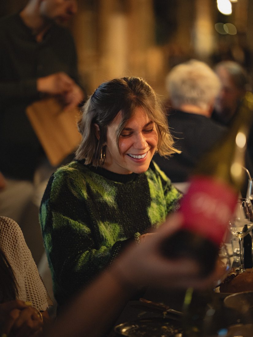 Convive souriante à table, ambiance chaleureuse d'un restaurant à Toulouse
