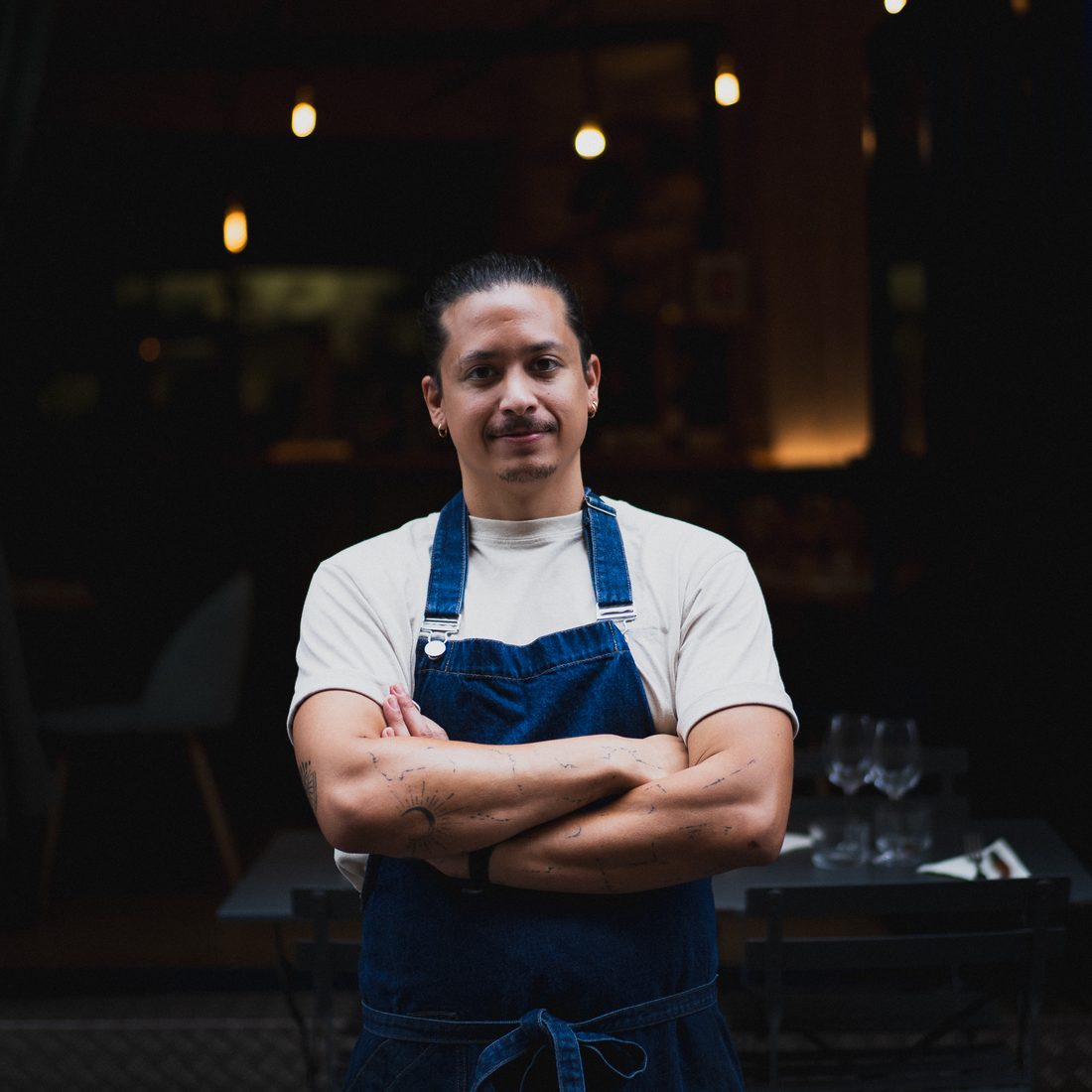 Portrait d'un chef en tablier devant son restaurant à Toulouse