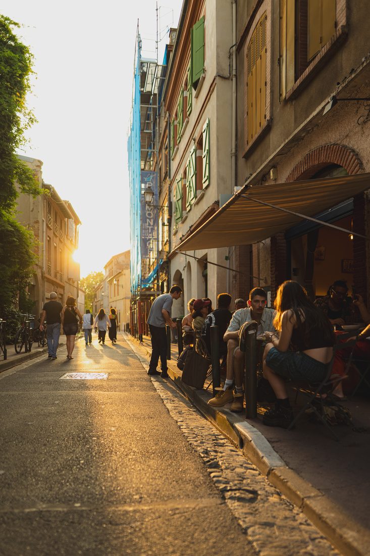 Terrasse d'un restaurant à Toulouse à l'heure dorée, ambiance de rue